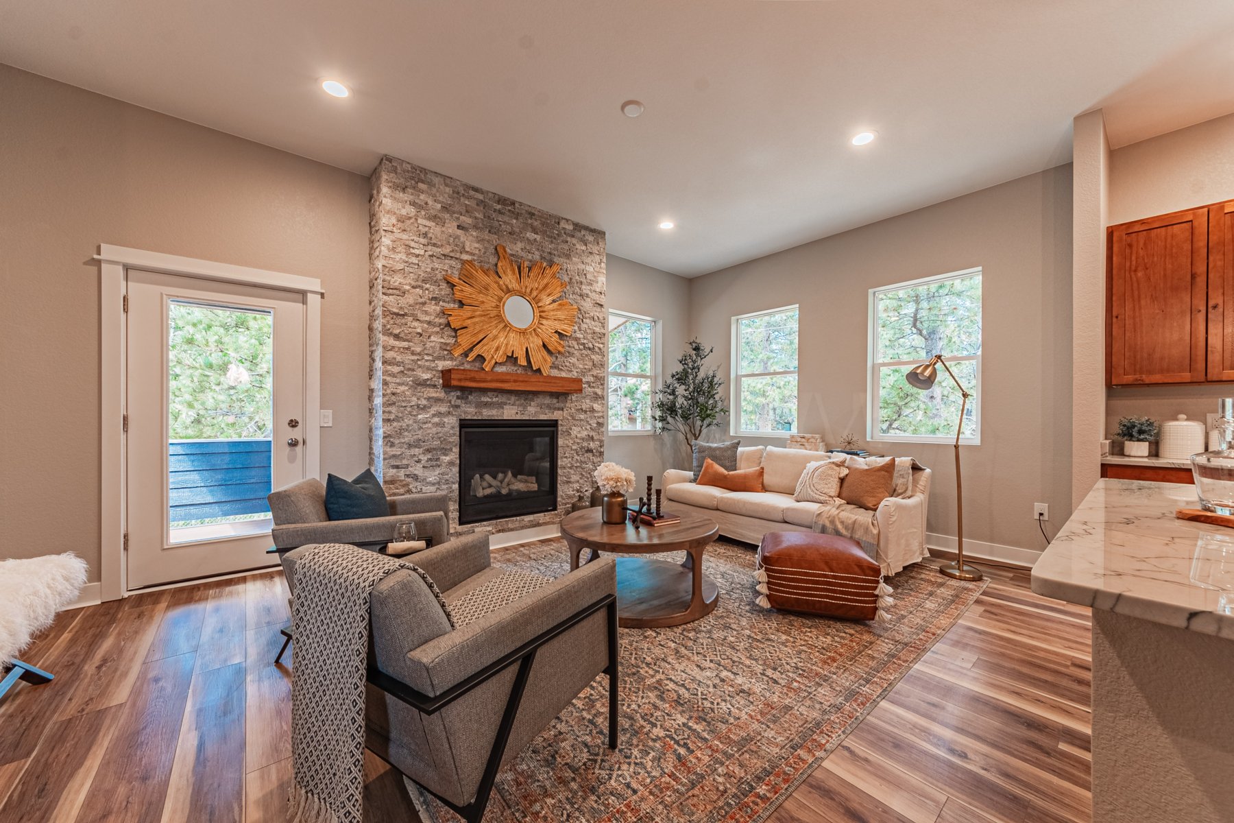 Great room with couches, fireplace, and deck door.