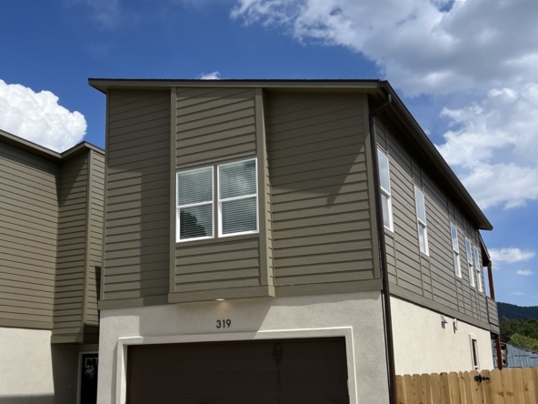 Front yard, fence, and driveway of 319 Spruce Meadow Grove