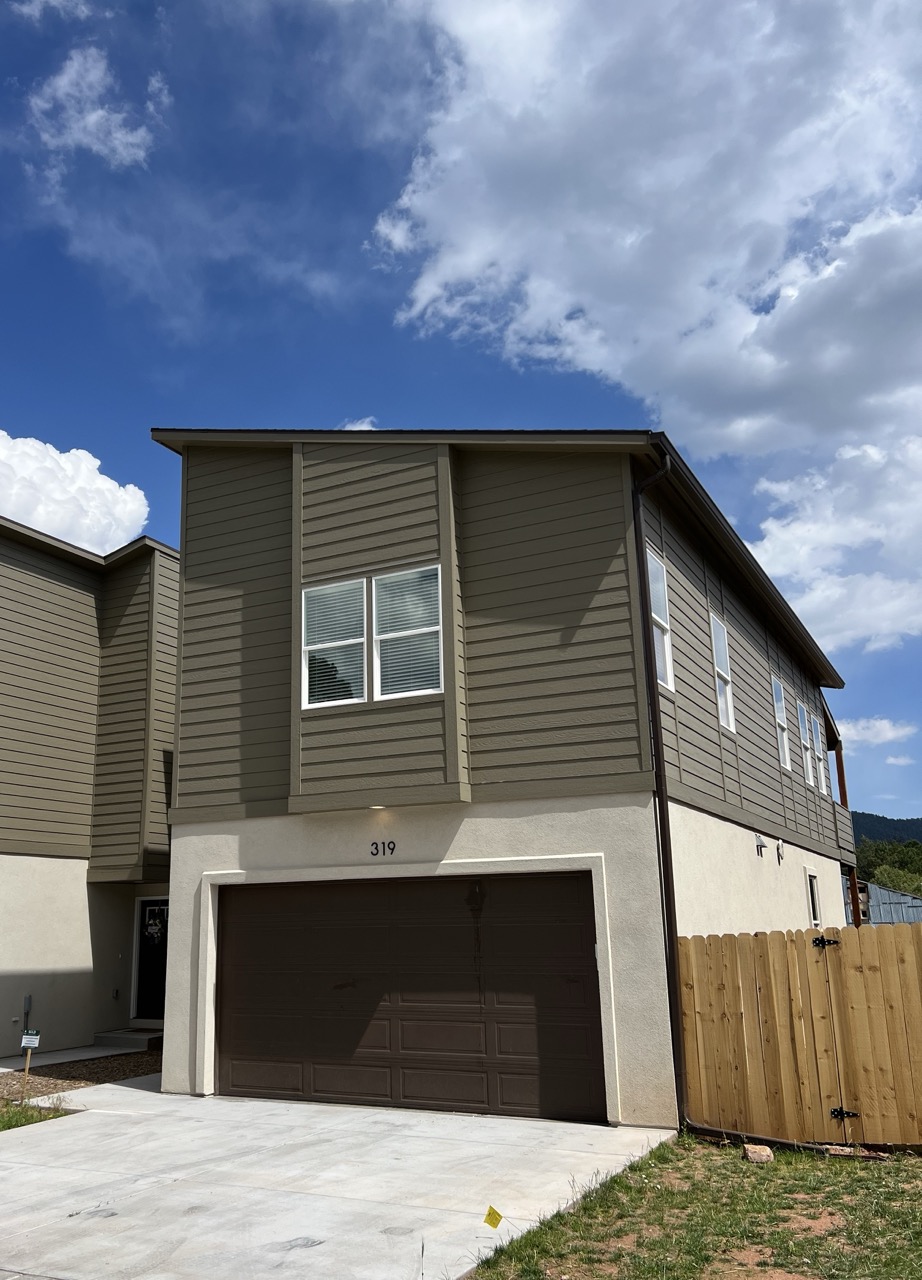 Front yard, fence, and driveway of 319 Spruce Meadow Grove