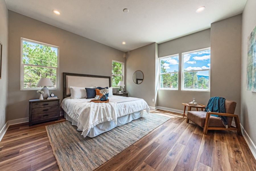 Primary bedroom with windows and trees